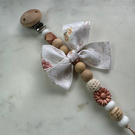Speenkoord koperbloem met strik, koperkleurige accenten, wit en houtlook. 